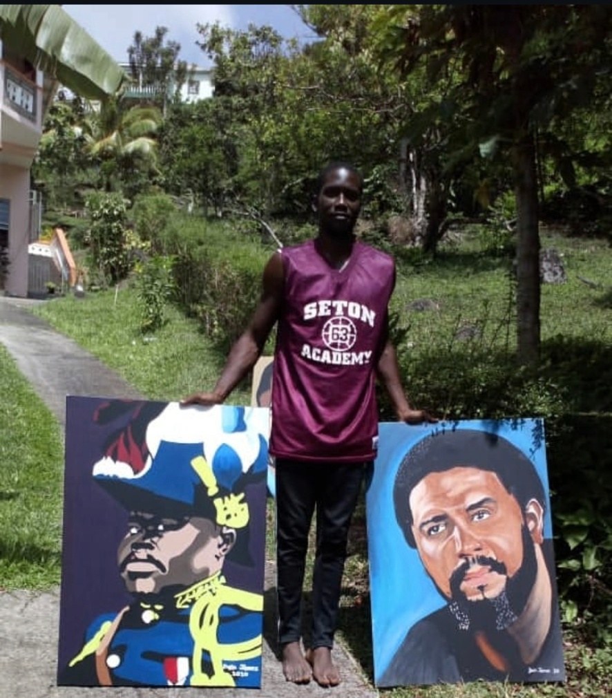 Artist Dain James holding two portrait paintings outdoors in Grenada